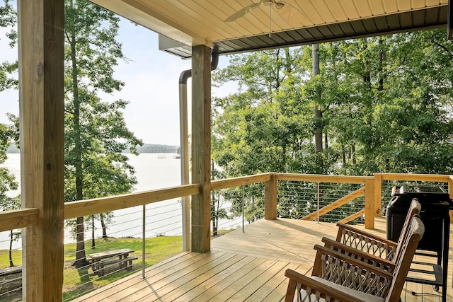 deck with ceiling fan and a water view