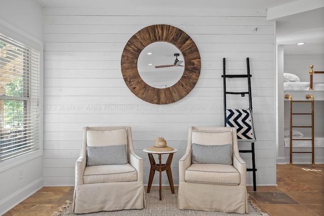 living area featuring a healthy amount of sunlight and wooden walls