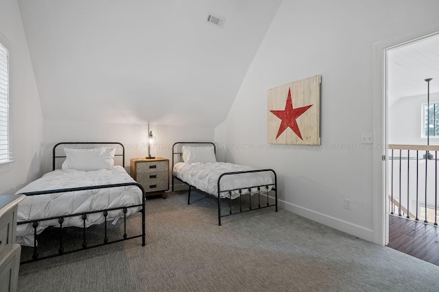 carpeted bedroom with lofted ceiling and multiple windows