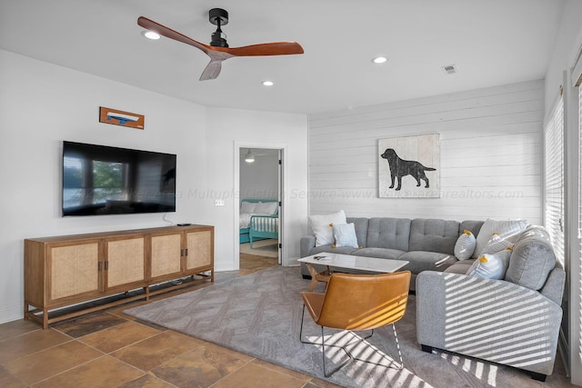 living room featuring wooden walls and ceiling fan