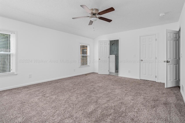 unfurnished bedroom featuring ceiling fan, carpet floors, a textured ceiling, and connected bathroom