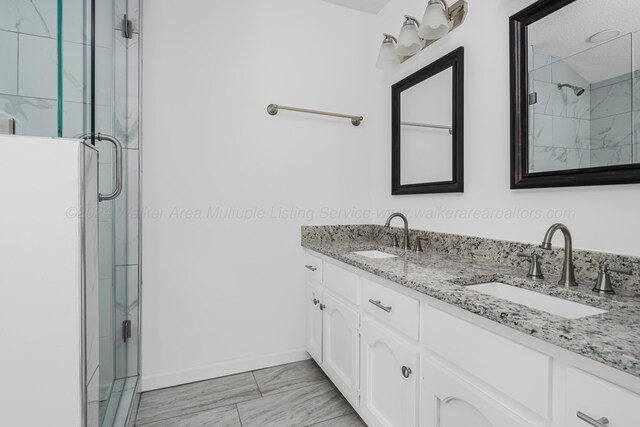 bathroom featuring vanity and a shower with door