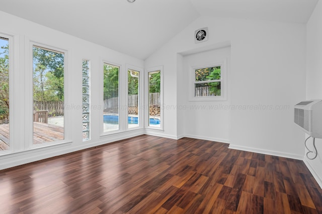 spare room with plenty of natural light, dark wood-type flooring, and lofted ceiling