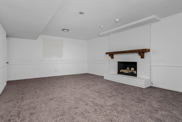 unfurnished living room featuring dark colored carpet, a textured ceiling, and a fireplace