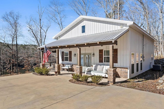 view of front facade with central AC unit, covered porch, and french doors