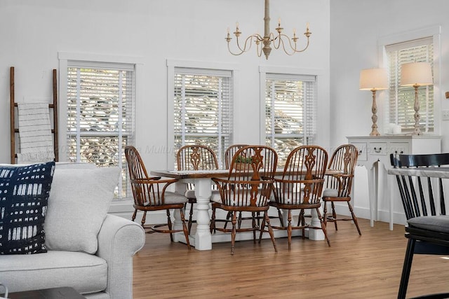 dining area featuring wood-type flooring and a notable chandelier