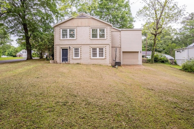 rear view of property with a yard and a garage