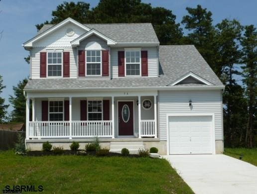 colonial inspired home featuring a porch, a front yard, and a garage