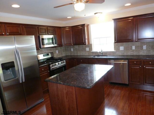 kitchen featuring ceiling fan, sink, a kitchen island, dark hardwood / wood-style flooring, and stainless steel appliances