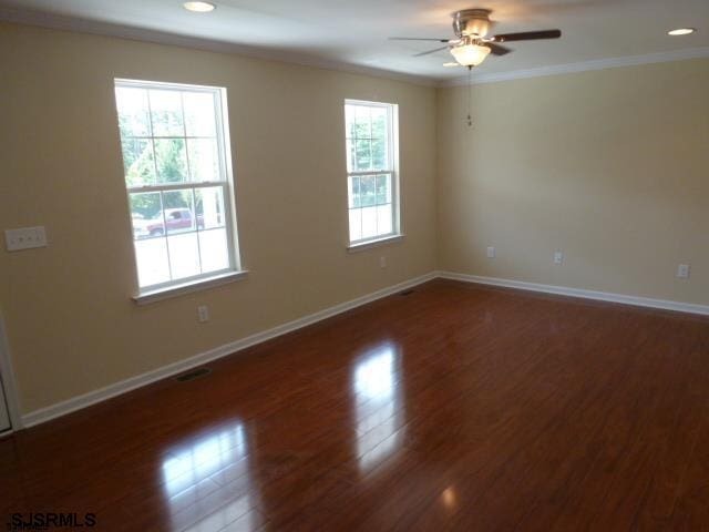 unfurnished room featuring a healthy amount of sunlight, crown molding, ceiling fan, and dark hardwood / wood-style flooring