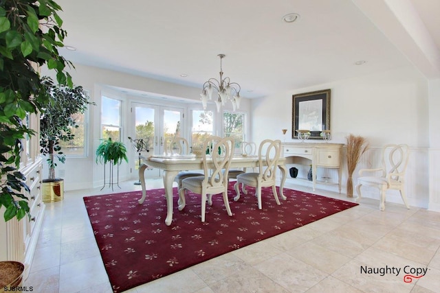 tiled dining room featuring a notable chandelier and french doors