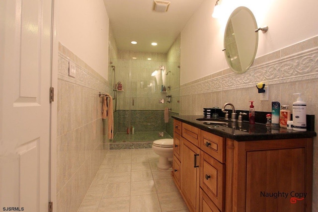 bathroom featuring an enclosed shower, vanity, tile walls, tile flooring, and toilet