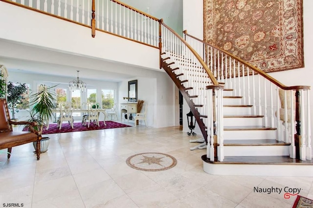 staircase with light tile flooring and a chandelier