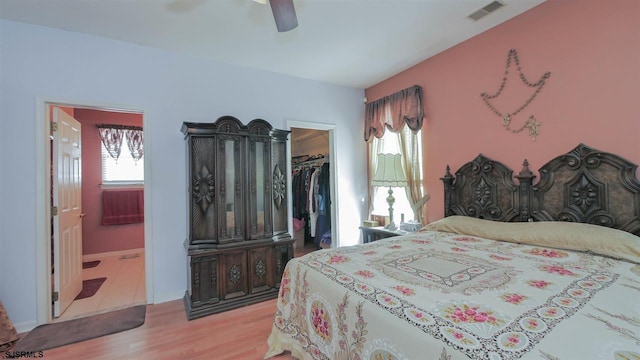 bedroom featuring a spacious closet, light tile floors, a closet, ensuite bathroom, and ceiling fan