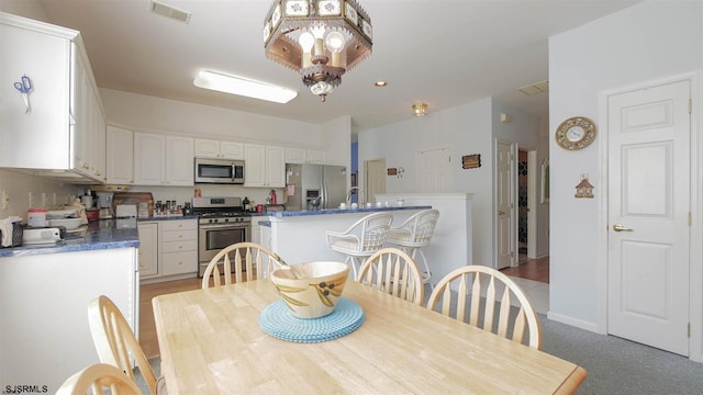 dining room featuring an inviting chandelier and dark carpet