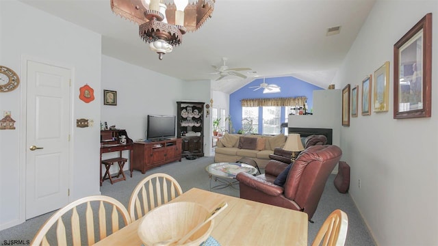 dining area featuring vaulted ceiling, carpet flooring, and ceiling fan with notable chandelier