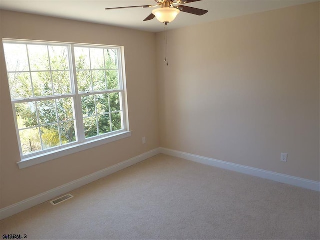 carpeted empty room featuring a healthy amount of sunlight and ceiling fan