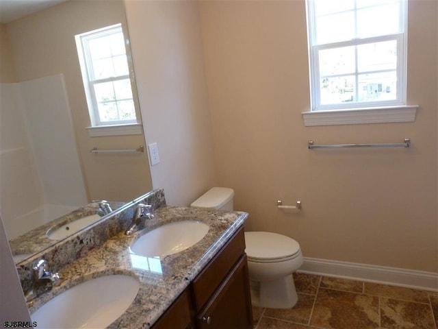 bathroom with dual sinks, tile flooring, large vanity, and toilet