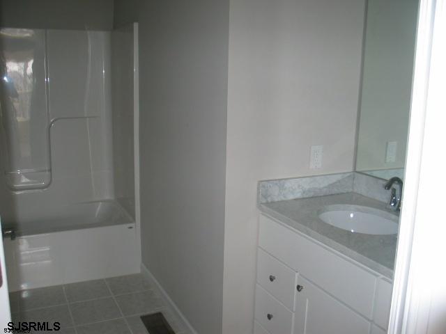 bathroom with tile floors, shower / washtub combination, and vanity