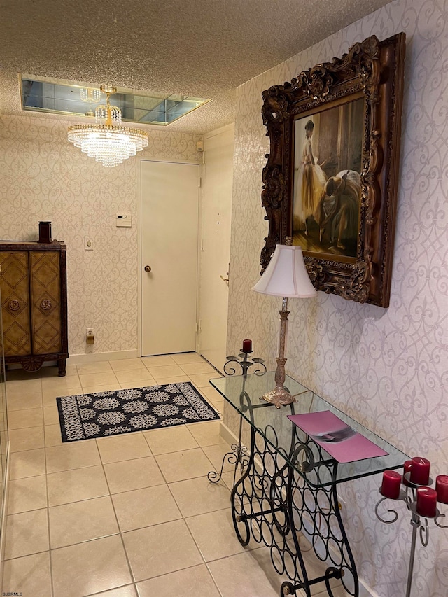 entryway with light tile patterned floors, a textured ceiling, and an inviting chandelier