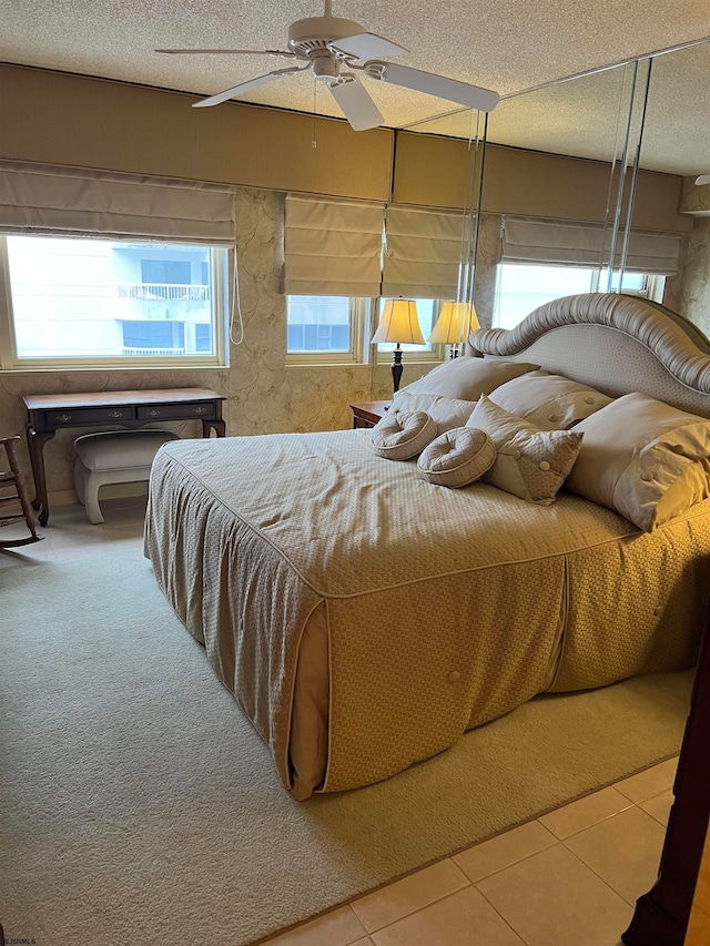 tiled bedroom featuring ceiling fan and a textured ceiling