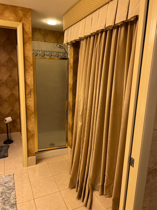 bathroom featuring tile patterned flooring and tiled shower