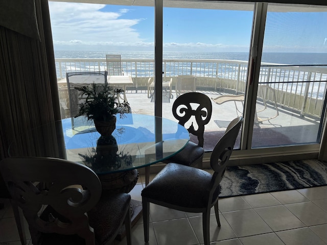 dining area featuring tile patterned flooring, a water view, and a view of the beach