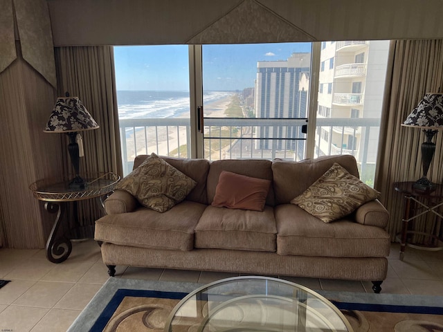 living room featuring plenty of natural light, a water view, and light tile patterned floors