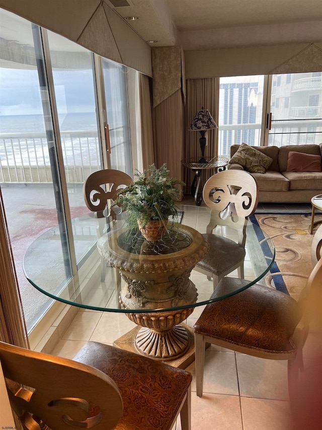 dining room featuring tile patterned flooring and a water view