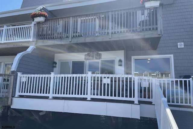 back of house featuring a water view and a balcony