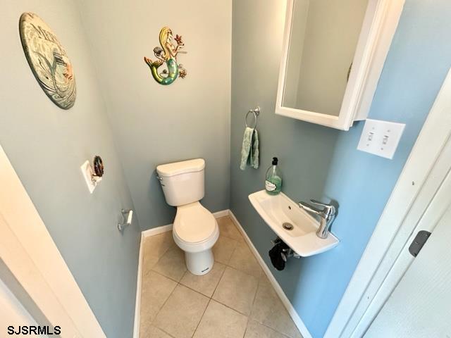 bathroom with tile patterned flooring, toilet, and sink