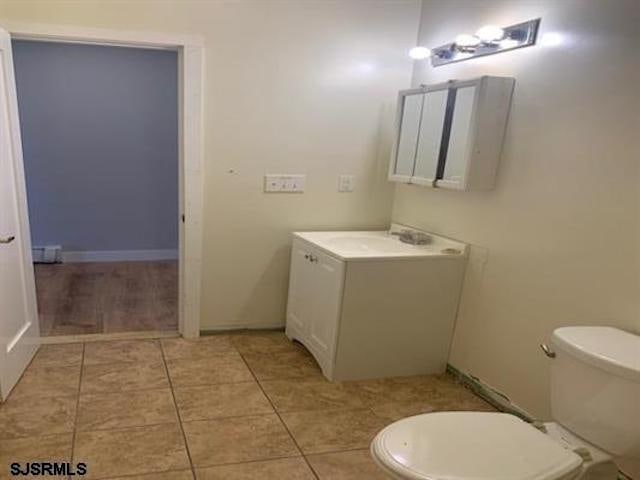 bathroom featuring vanity, tile patterned flooring, and toilet