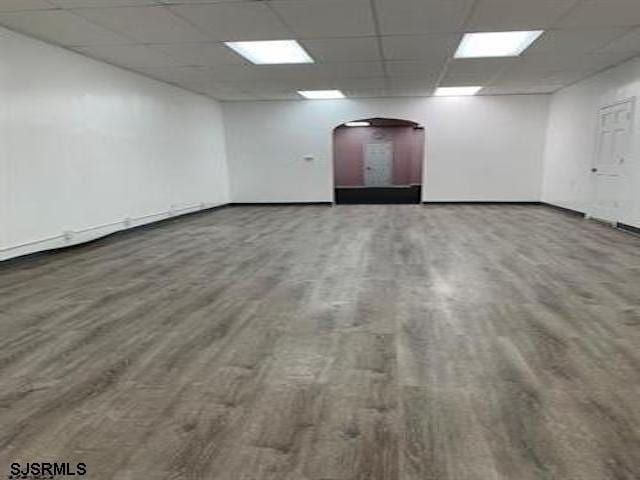 unfurnished room with a drop ceiling and hardwood / wood-style floors