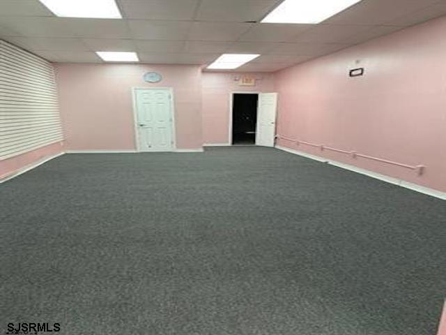 unfurnished room with a drop ceiling and carpet