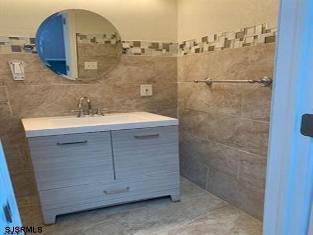 bathroom featuring vanity and tile walls