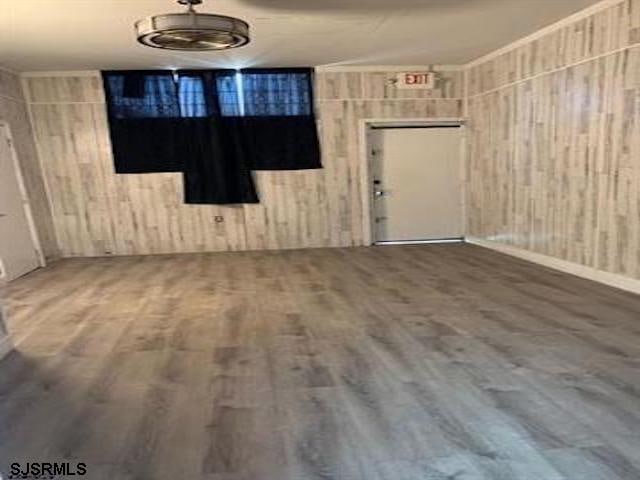 empty room featuring hardwood / wood-style flooring and wood walls