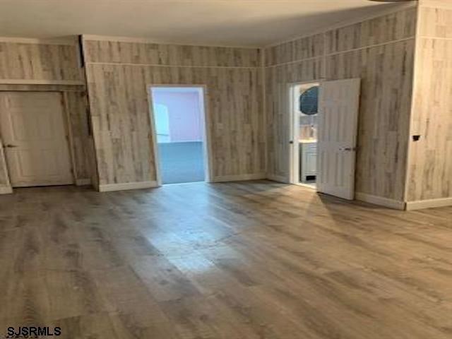 spare room featuring hardwood / wood-style flooring and wood walls