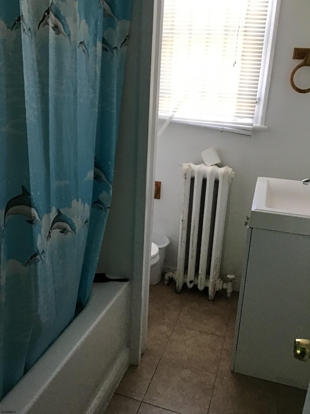 full bathroom featuring vanity, tile floors, toilet, shower / bath combination with curtain, and radiator