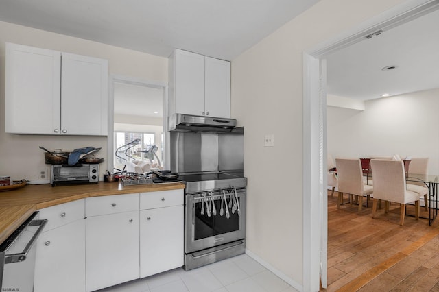 kitchen with white cabinets, butcher block countertops, stainless steel appliances, and light wood-type flooring