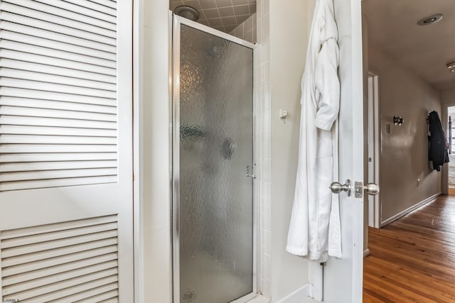 bathroom with walk in shower and wood-type flooring