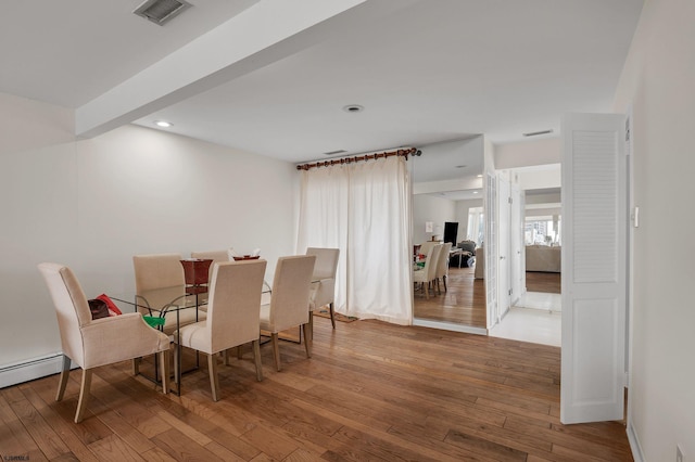 dining area featuring beam ceiling and light wood-type flooring