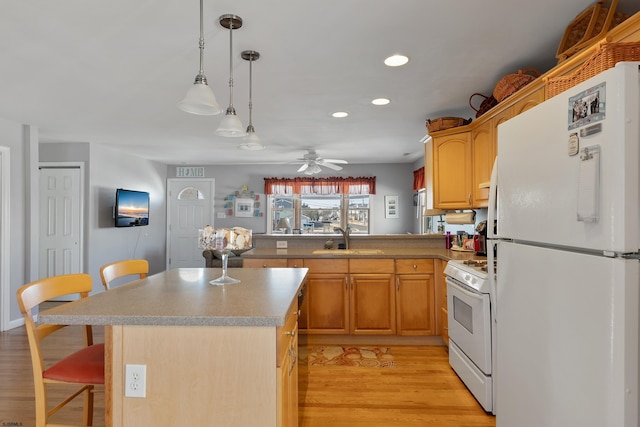 kitchen with ceiling fan, white appliances, light wood-type flooring, and a kitchen breakfast bar