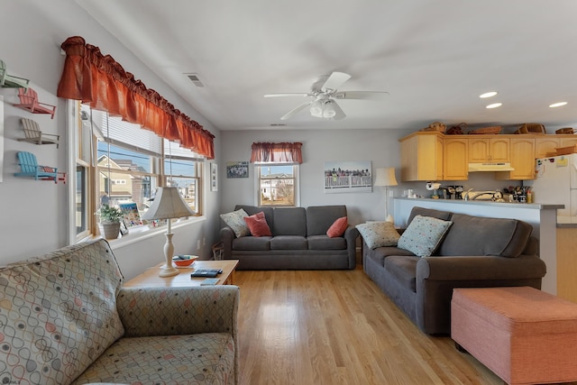 living room featuring light hardwood / wood-style floors and ceiling fan