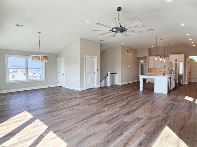 unfurnished living room featuring ceiling fan, dark hardwood / wood-style flooring, lofted ceiling, and sink