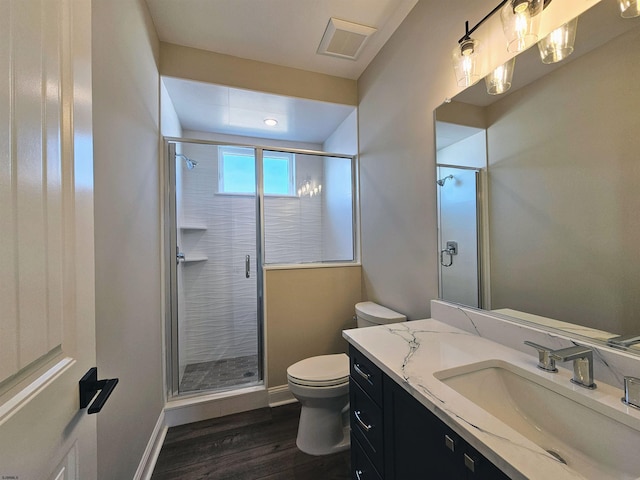 bathroom with hardwood / wood-style flooring, vanity, toilet, and a shower with shower door