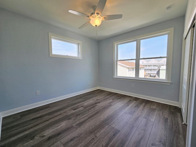 spare room with ceiling fan and dark hardwood / wood-style flooring