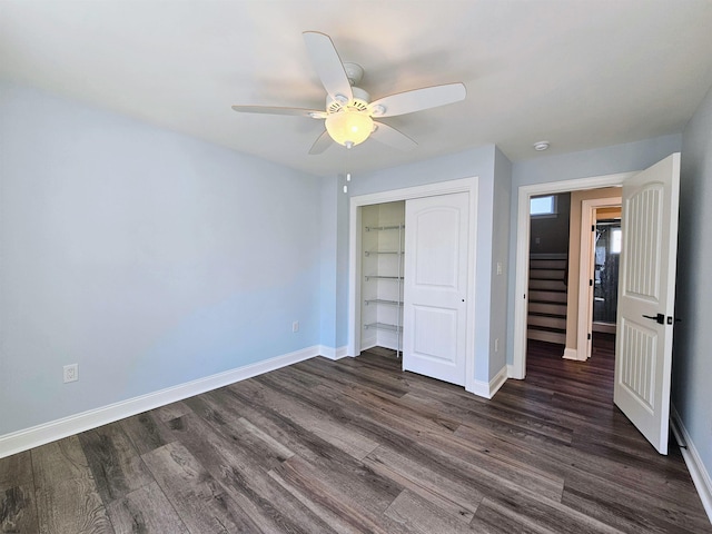 unfurnished bedroom with ceiling fan, a closet, and dark wood-type flooring