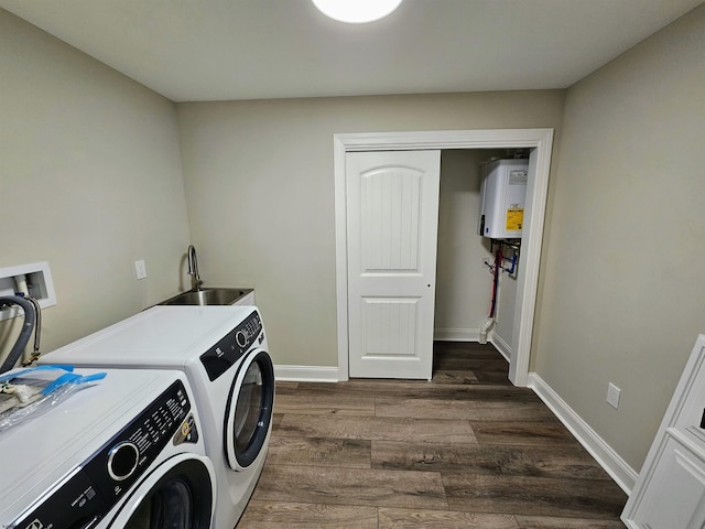 clothes washing area with separate washer and dryer, water heater, sink, and dark hardwood / wood-style floors