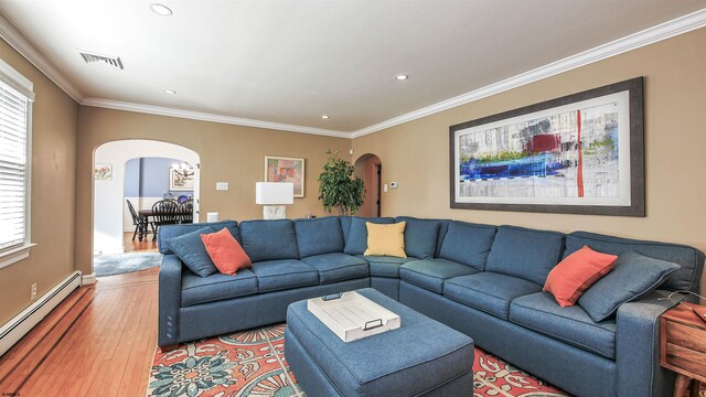 living room featuring baseboard heating, ornamental molding, and light hardwood / wood-style floors