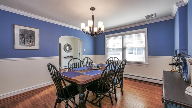 dining room featuring a notable chandelier, a baseboard radiator, ornamental molding, and wood-type flooring